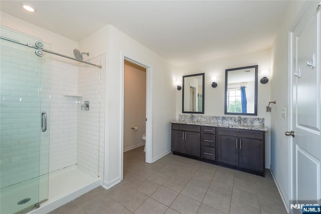 601 Charleston Drive, Unit 601 Monroe Township, NJ 08831 - Photo 25 of 45 a bathroom with a granite countertop sink mirror and shower