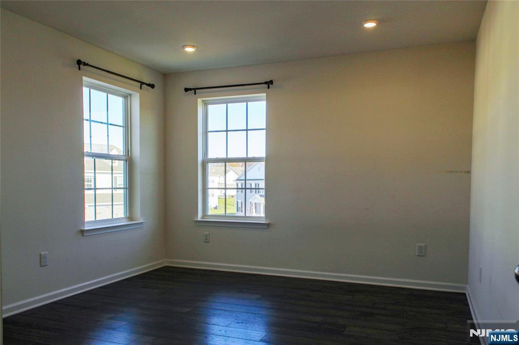 601 Charleston Drive, Unit 601 Monroe Township, NJ 08831 - Photo 26 of 45 an empty room with wooden floor and windows