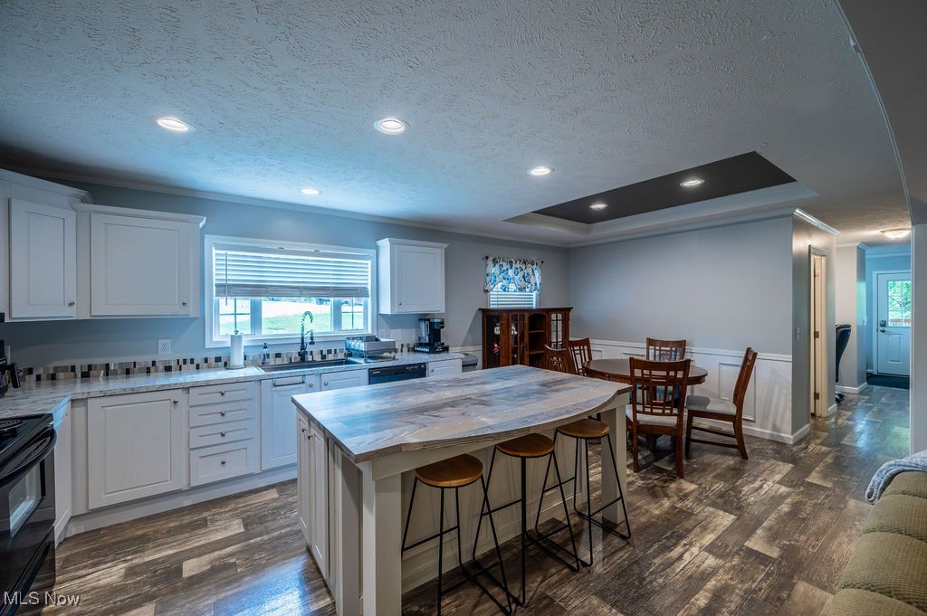560 Wine Road Elizabeth, WV 26143 - Photo 21 of 50 Kitchen featuring a center island, white cabinetry, dark wood-style floors, a breakfast bar, and a textured ceiling