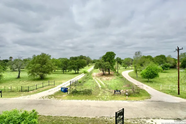 an aerial view of residential houses with outdoor space and trees