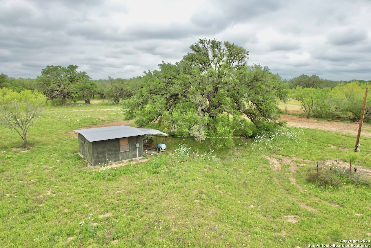7711 Devine Tx 78016 Devine, TX 78016 - Photo 7 of 51 a swimming pool with some trees in the background