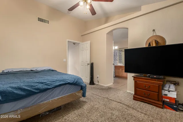a bedroom with a bed and a flat screen tv