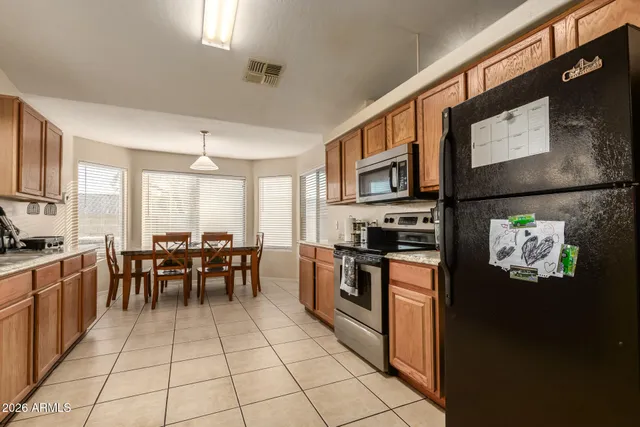 a kitchen with stainless steel appliances granite countertop a refrigerator and a stove top oven