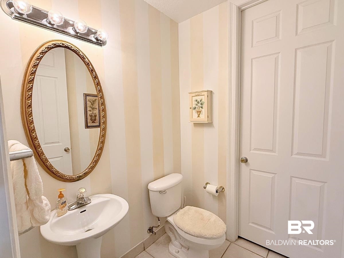 27284 Gulf Road, Unit 212 Orange Beach, AL 36561 - Photo 23 of 35 Half bath featuring wallpapered walls and tile patterned floors