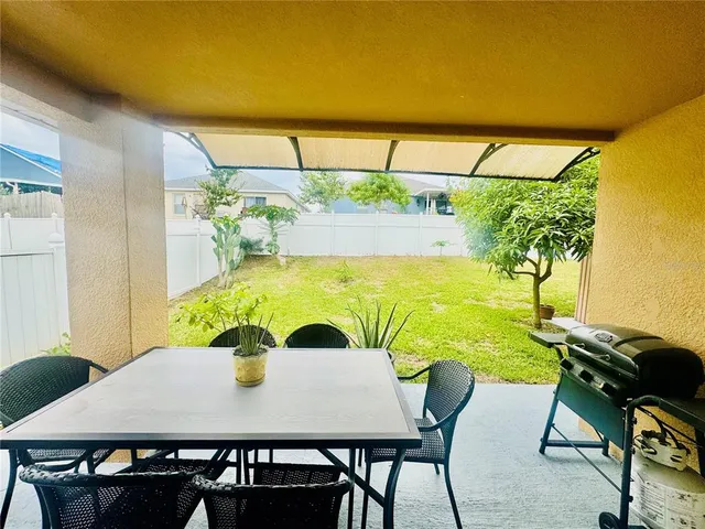 a view of a house with backyard and sitting area