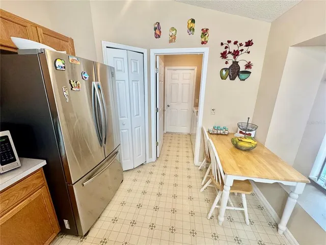 a view of a living room with furniture and a refrigerator