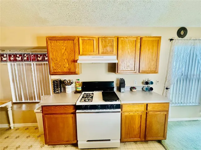 a kitchen with granite countertop cabinets and window