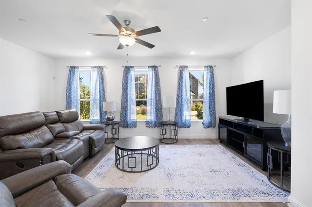 a living room with furniture a ceiling fan and a rug