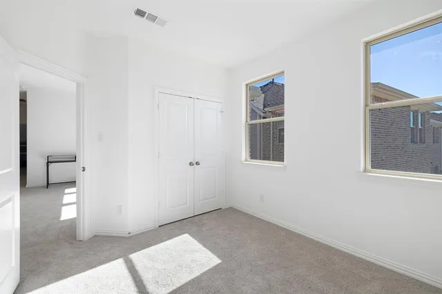 a bedroom with a large bed and a chandelier fan