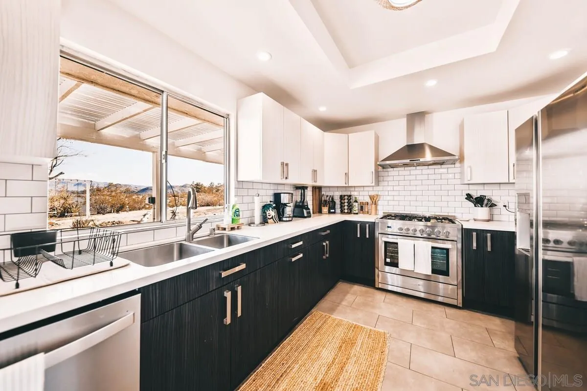 3900 Ave Tortuga Joshua Tree, CA 92252 - Photo 16 of 28 a kitchen with stainless steel appliances granite countertop a sink a stove and a refrigerator