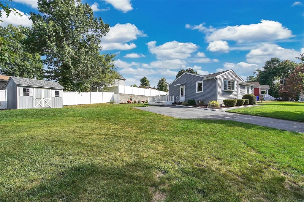 92 Agnes Street Springfield, MA 01118 - Photo 3 of 29 a view of a house with a big yard potted plants and large tree