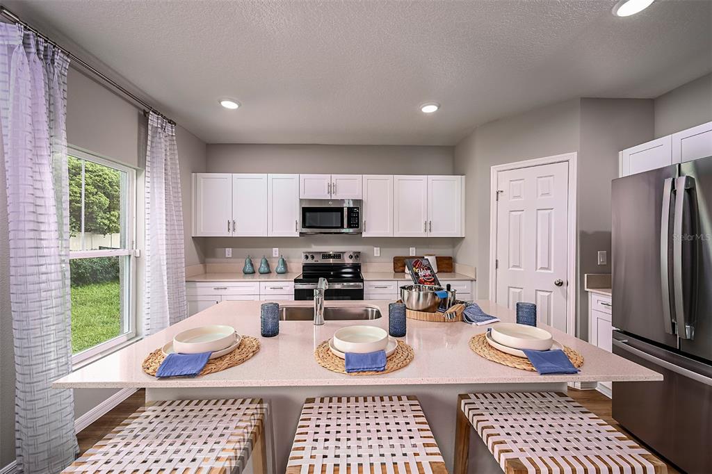 1334 Palmeroy Road Haines City, FL 33844 - Photo 3 of 22 a kitchen with stainless steel appliances granite countertop a refrigerator sink and cabinets