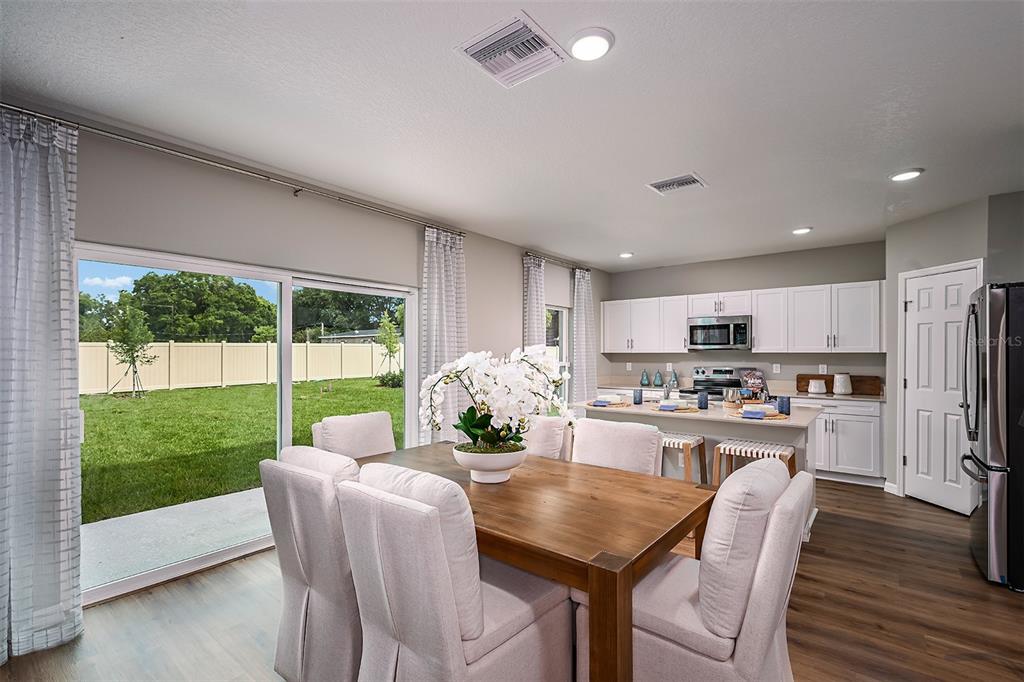 1334 Palmeroy Road Haines City, FL 33844 - Photo 7 of 22 a kitchen with stainless steel appliances granite countertop a stove a refrigerator a kitchen island a table and chairs