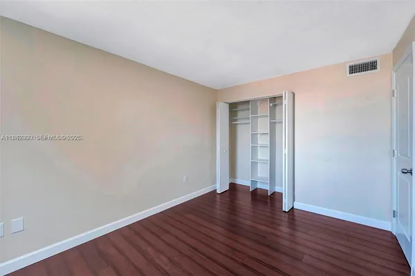 a view of an empty room with wooden floor