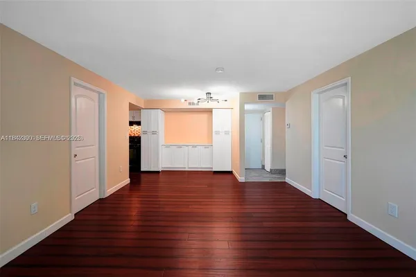 a view of empty room with wooden floor