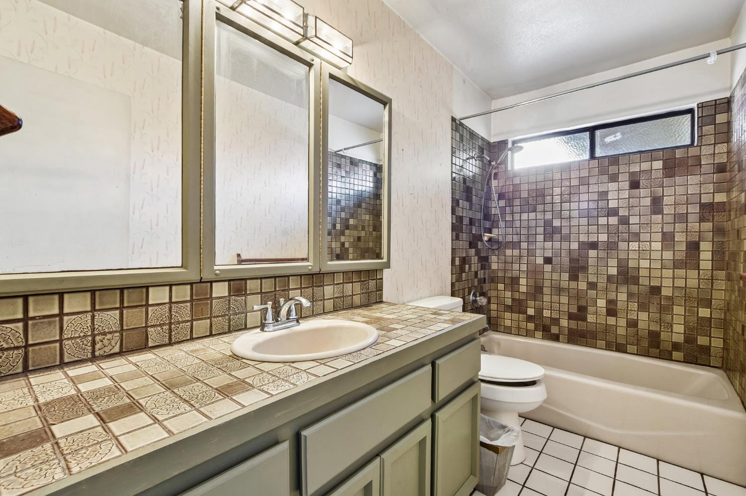 6180 Rustic Hills Drive Rocklin, CA 95677 - Photo 20 of 37 a bathroom with a granite countertop sink a toilet a mirror and shower