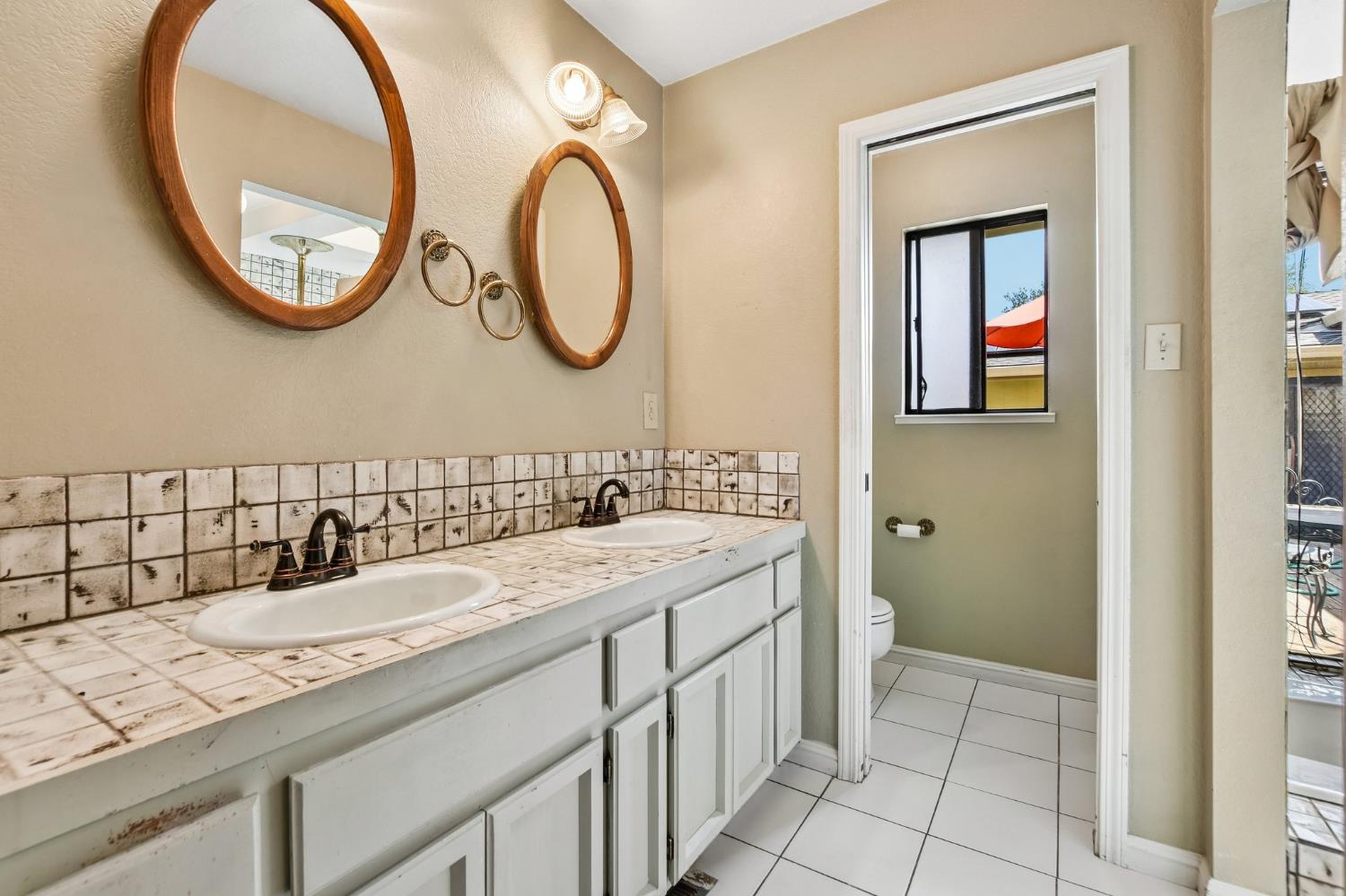6180 Rustic Hills Drive Rocklin, CA 95677 - Photo 21 of 37 a bathroom with a granite countertop sink and a mirror