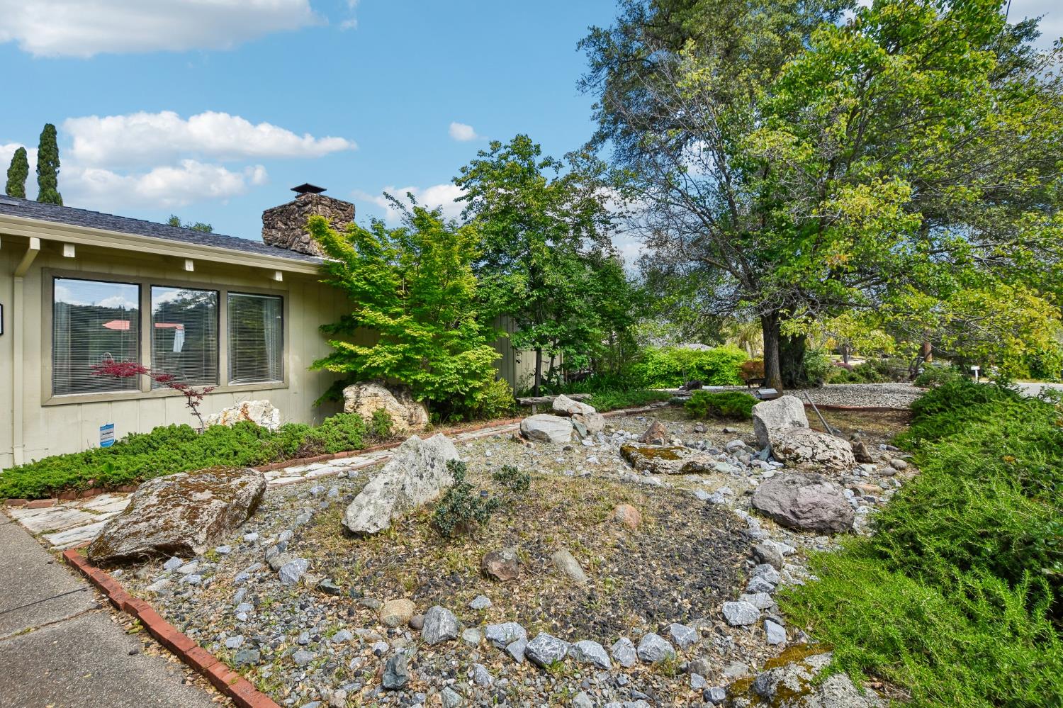 6180 Rustic Hills Drive Rocklin, CA 95677 - Photo 34 of 37 a view of a house with a small yard and a tree
