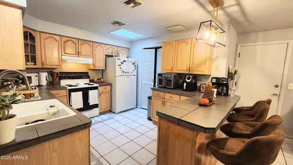 a kitchen with a table chairs refrigerator and a sink