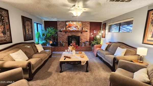 a living room with furniture a fireplace and a large window