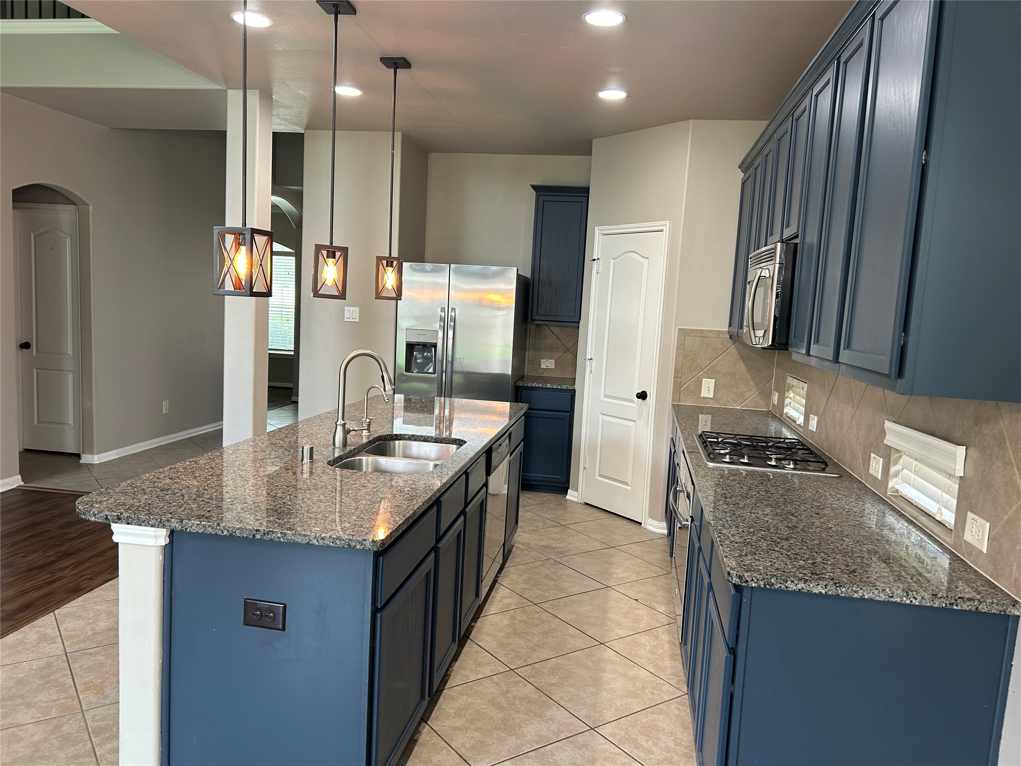 7936 Lake Commons Drive Rosenberg, TX 77469 - Photo 32 of 33 a kitchen with stainless steel appliances granite countertop a sink a stove and a refrigerator