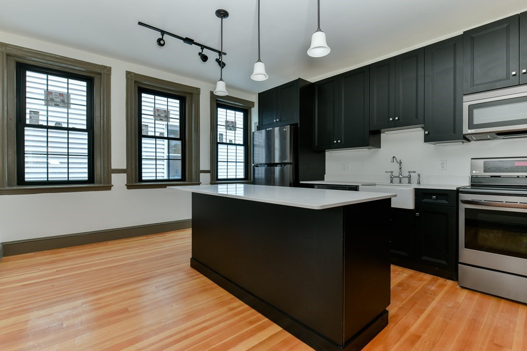 a kitchen with granite countertop wooden cabinets a stove top oven and granite counter tops
