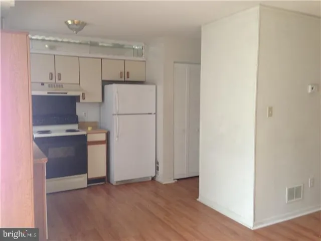 a kitchen with a refrigerator sink and cabinets