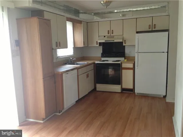 a kitchen with kitchen island a counter top space a sink and a refrigerator