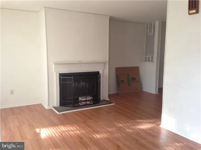 a view of an empty room with a fireplace and a window