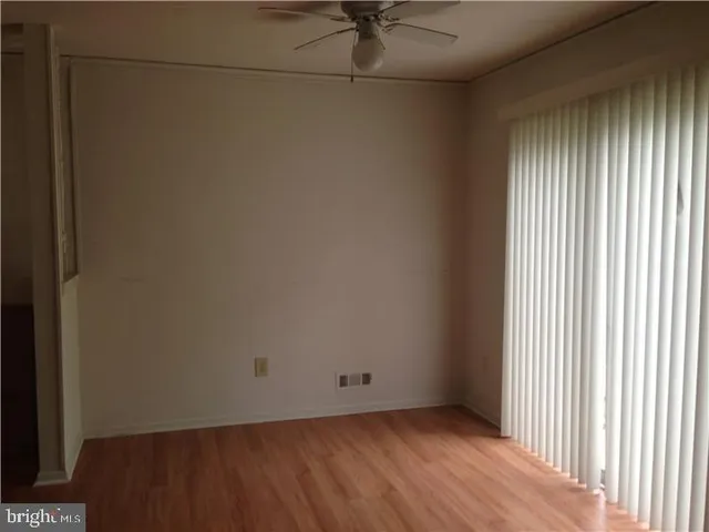 a view of a small space with wooden floor and a window