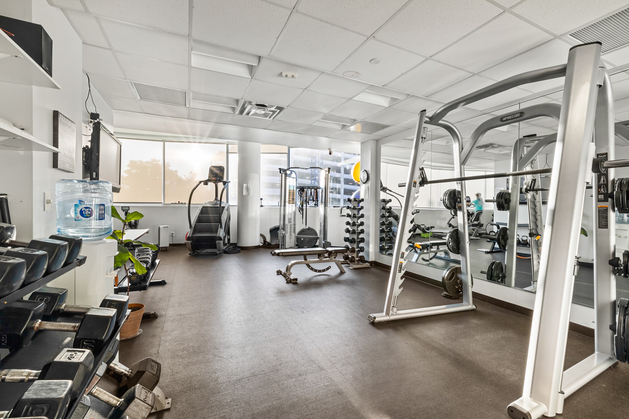 603 Davis Street, Unit 907 Austin, TX 78701 - Photo 19 of 22 Spacious, modern fitness center with cardio and strength zones—highlighted by a StairMaster, multiple weight stations, kettlebells, and a full dumbbell rack—designed for everything from quick morning workouts to full training sessions.