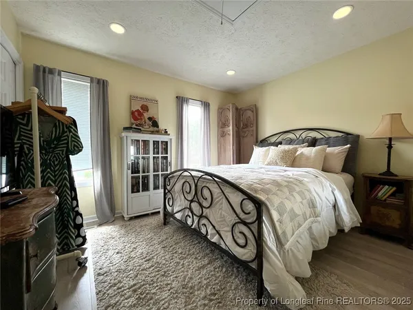 a bedroom with a bed and a flat tv screen on the dresser