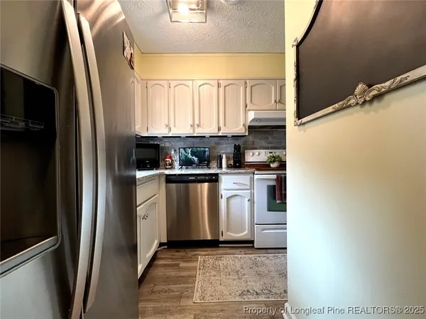 a kitchen with white cabinets and white appliances