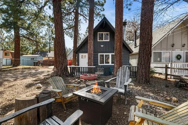a front view of a house with large trees