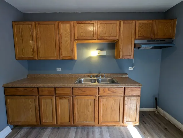 a kitchen with a sink cabinets and a wooden floor
