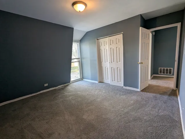 an empty room with windows and closet