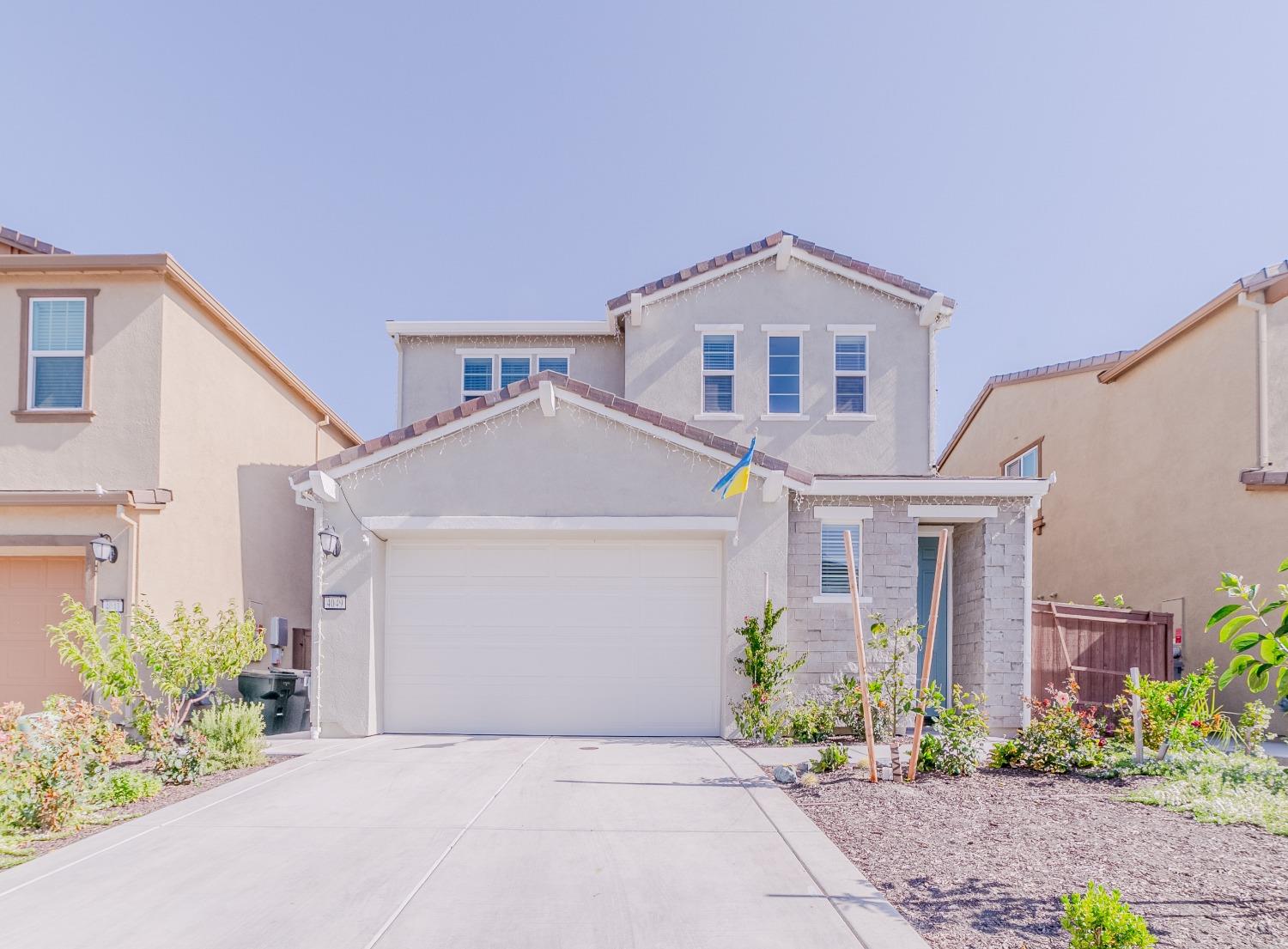 a front view of a house with a yard and a garage