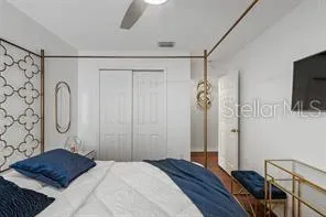 a bedroom with a bed and a flat tv screen on the dresser