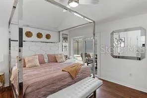 a bedroom with a bed and wooden floor