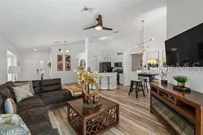 a living room with furniture a flat screen tv and kitchen view