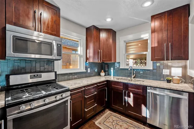 a kitchen with stainless steel appliances wooden cabinets and a stove top oven