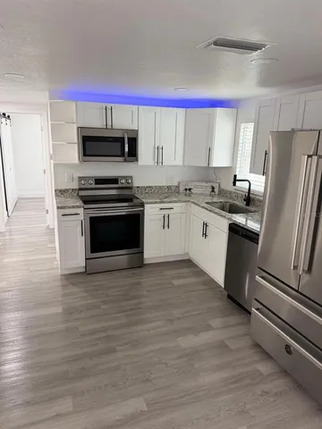 a kitchen with granite countertop a sink stove and refrigerator