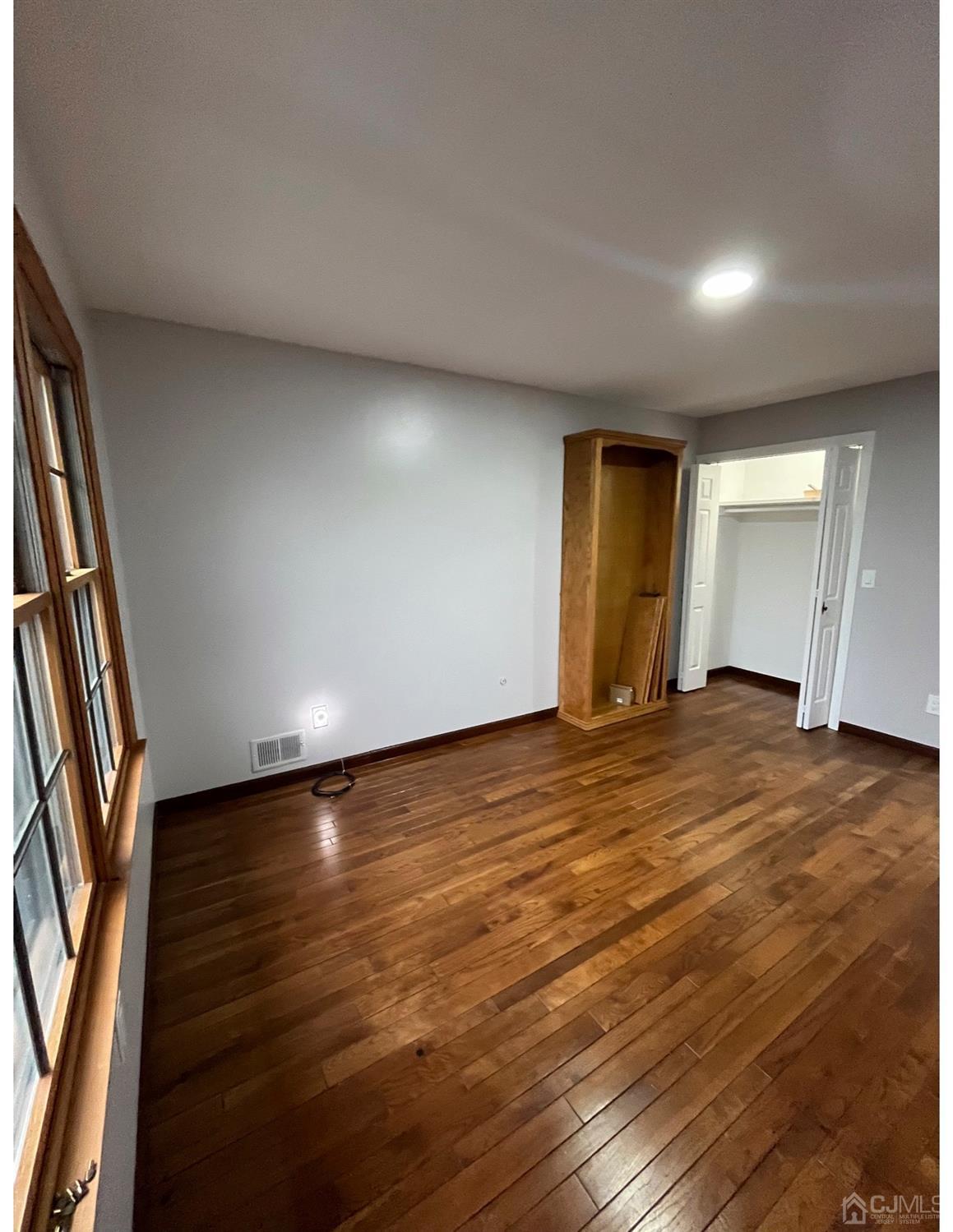 23 Pendleton Place Old Bridge, NJ 08857 - Photo 5 of 14 an empty room with wooden floor and windows
