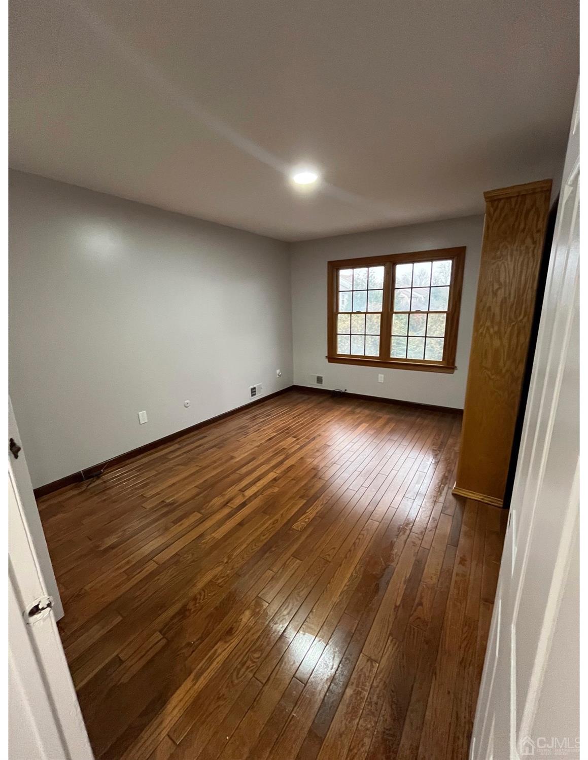 23 Pendleton Place Old Bridge, NJ 08857 - Photo 6 of 14 an empty room with wooden floor and windows