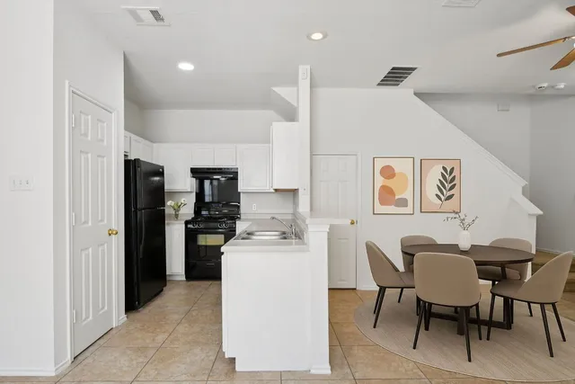 a kitchen with a dining table chairs and refrigerator