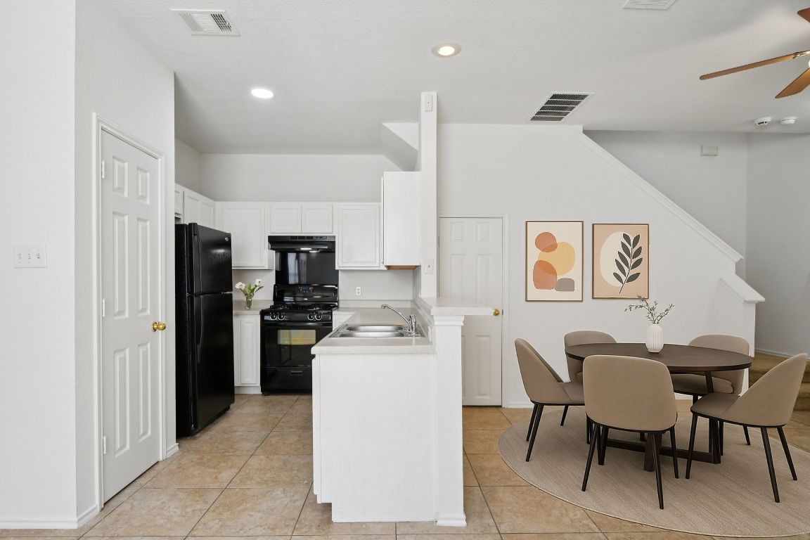14504 Harris Ridge Boulevard, Unit A Pflugerville, TX 78660 - Photo 5 of 23 a kitchen with a dining table chairs and refrigerator