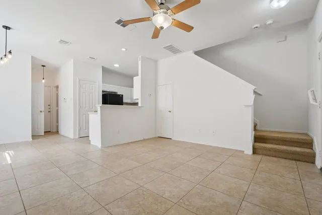 an empty room with windows and fan