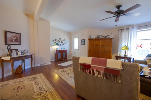 a living room with furniture wooden floor and a window
