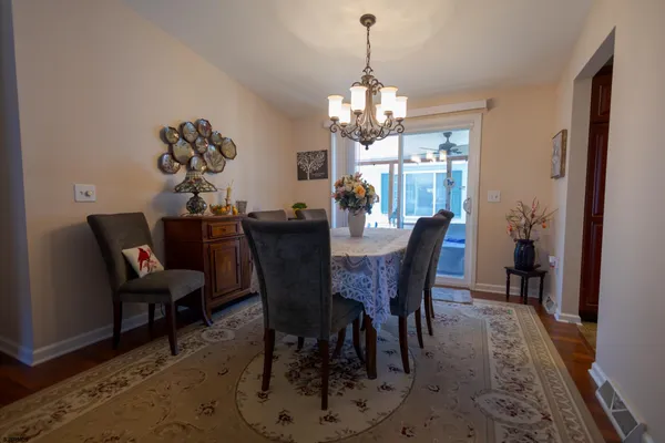 a view of a dining room with furniture a chandelier and wooden floor