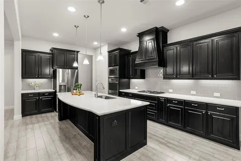 a large kitchen with stainless steel appliances wooden cabinets a stove a sink and a refrigerator